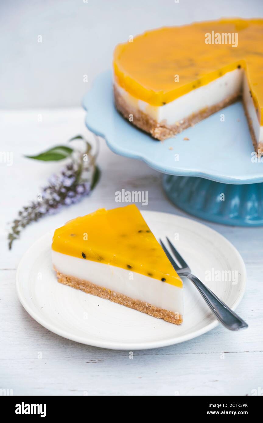 Fetta di crostata a strati con crosta crumble, latte di cocco, crema pasticcera e top di frutta Foto Stock