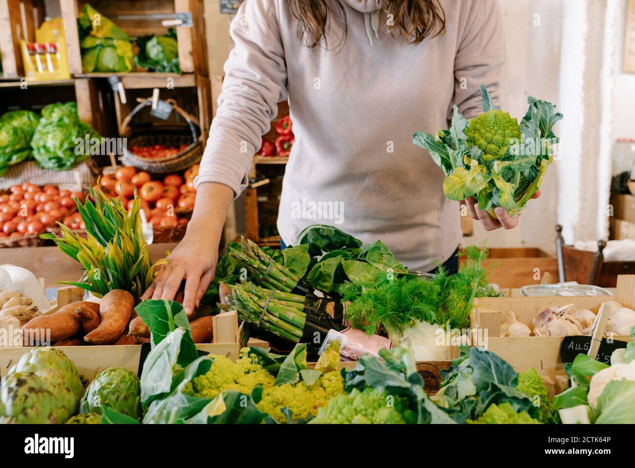 Donna che raccoglie verdura fresca sana in negozio Foto Stock