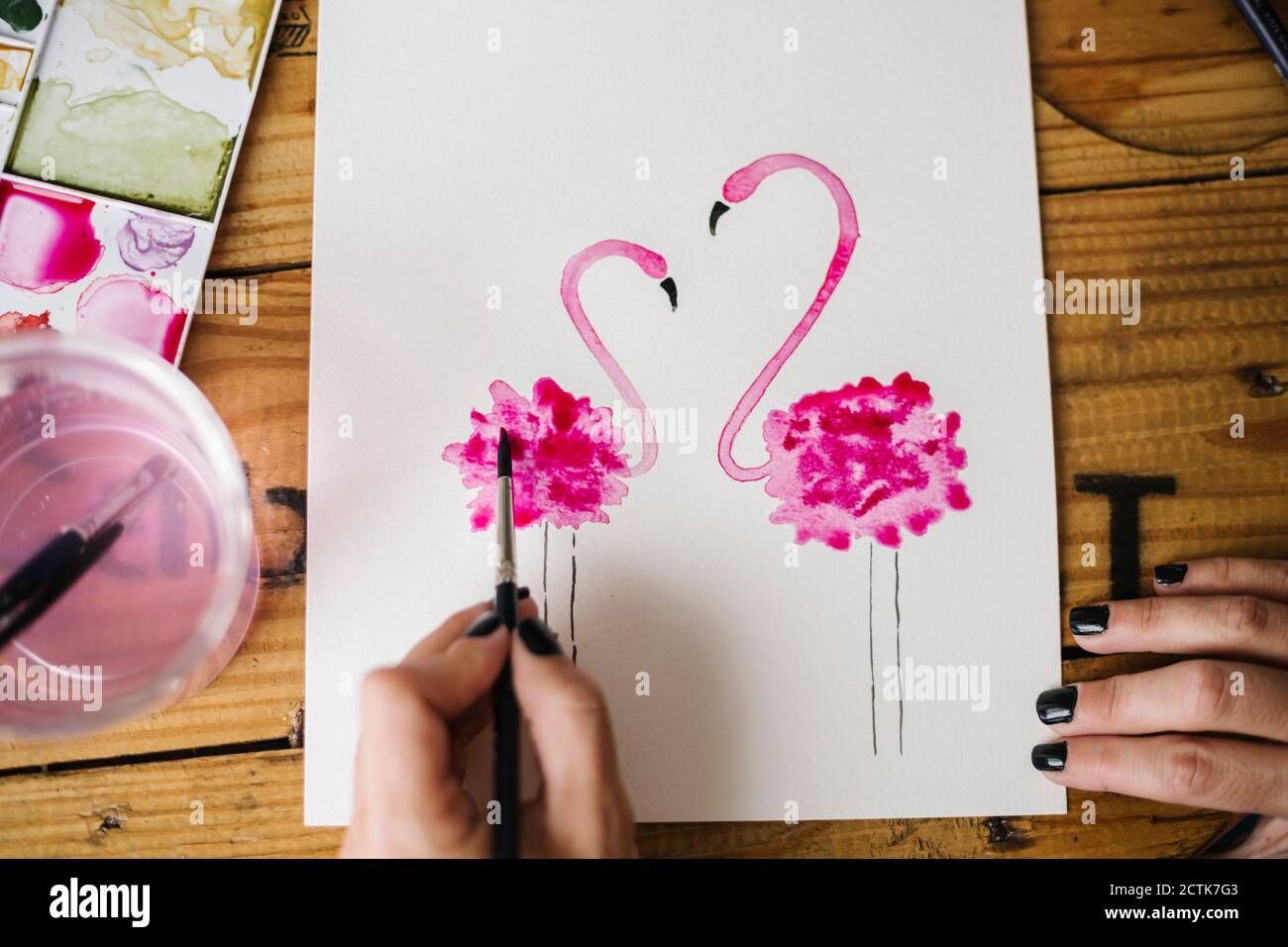 Primo piano di donna mano pittura animale fenicottero su carta Foto Stock