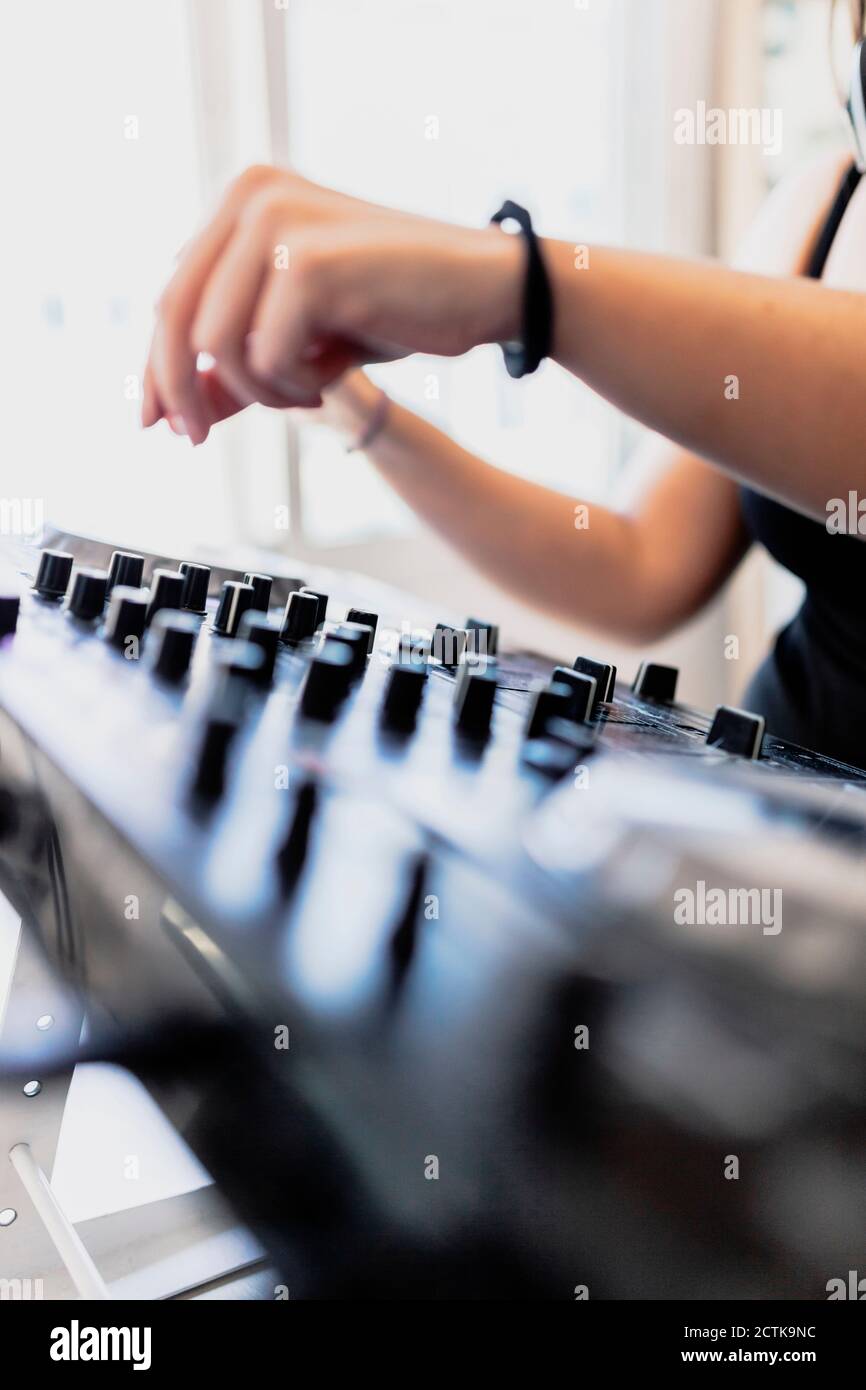 Mani di DJ club femminile mixando suono in studio di registrazione Foto Stock