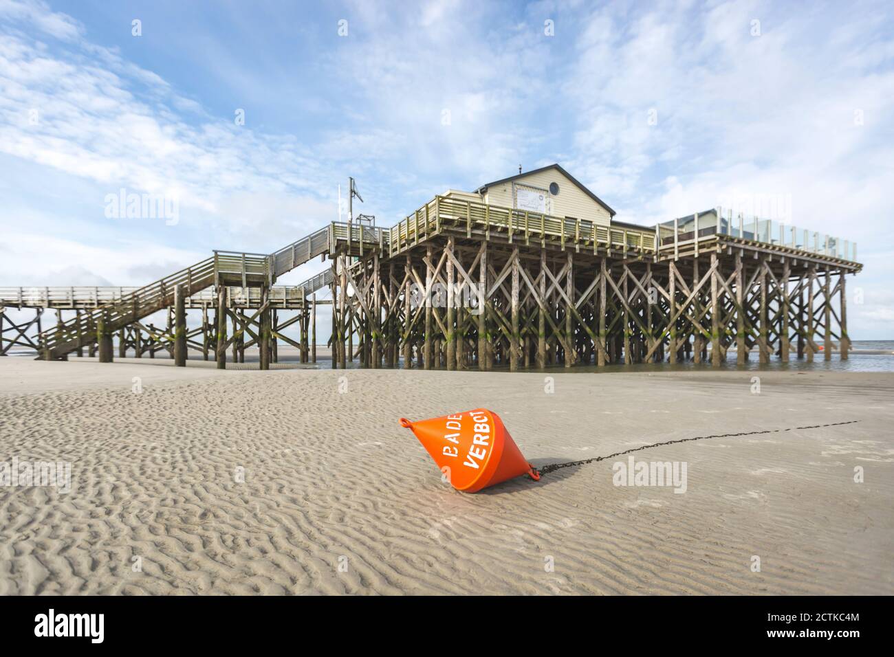 Germania, Schleswig-Holstein, Sankt Peter-Ording, Buoy giace sulla spiaggia di sabbia di fronte al molo Foto Stock