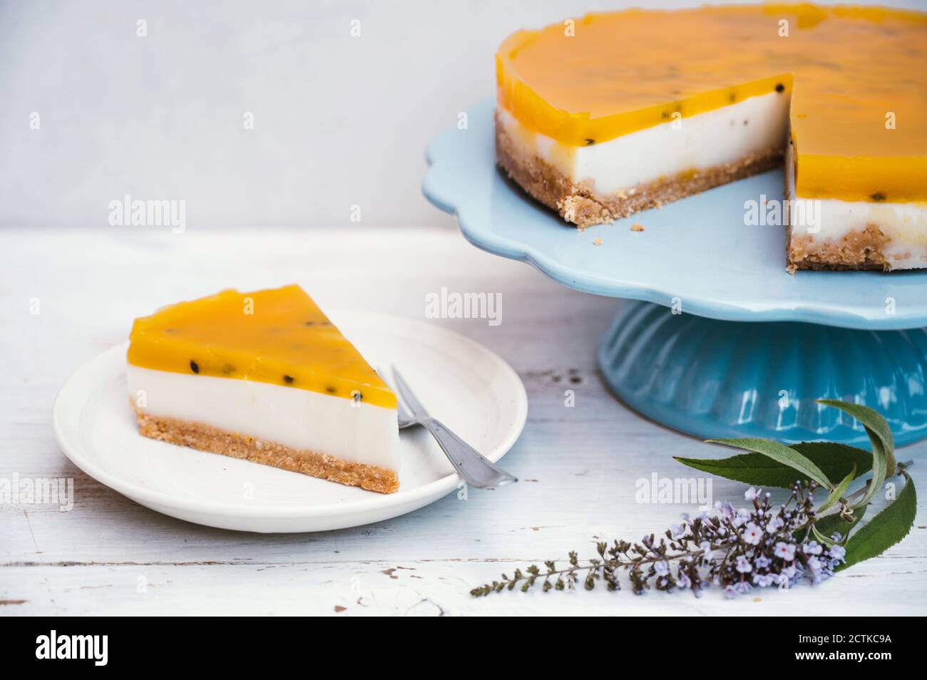 Fetta di crostata a strati con crosta crumble, latte di cocco, crema pasticcera e top di frutta Foto Stock