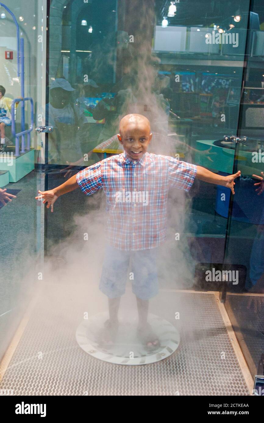 Huntsville, Alabama, Sci-quest Hands-on Science Center, all'interno dell'interno Black African ragazzo che si divertono movimento, simulatore di tornado vorticoso nebbia d'acqua Foto Stock