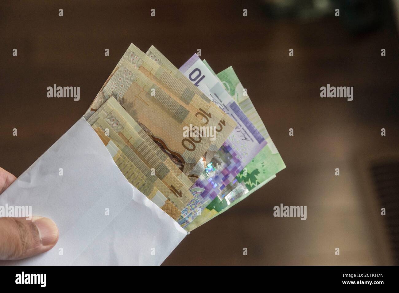 Bollette in dollari canadesi miste all'interno di un involucro Foto Stock