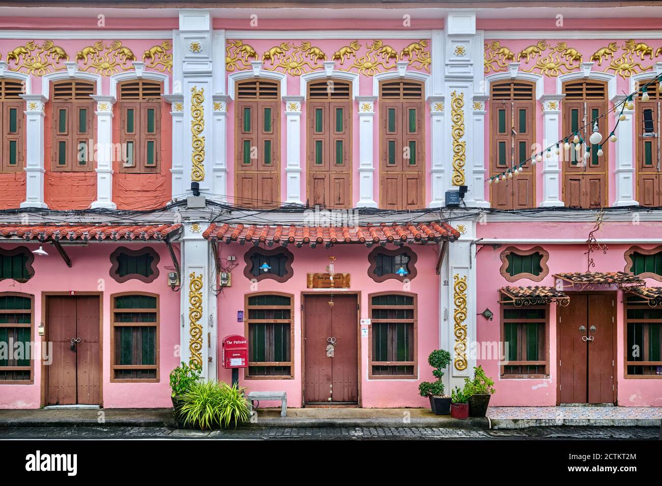 Una fila di pittoresche case in stile sino-portoghese o Paranakan rosa a Soi Rommannee (Rommanni/Romanee) nella zona della Città Vecchia di Phuket, Thailandia Foto Stock