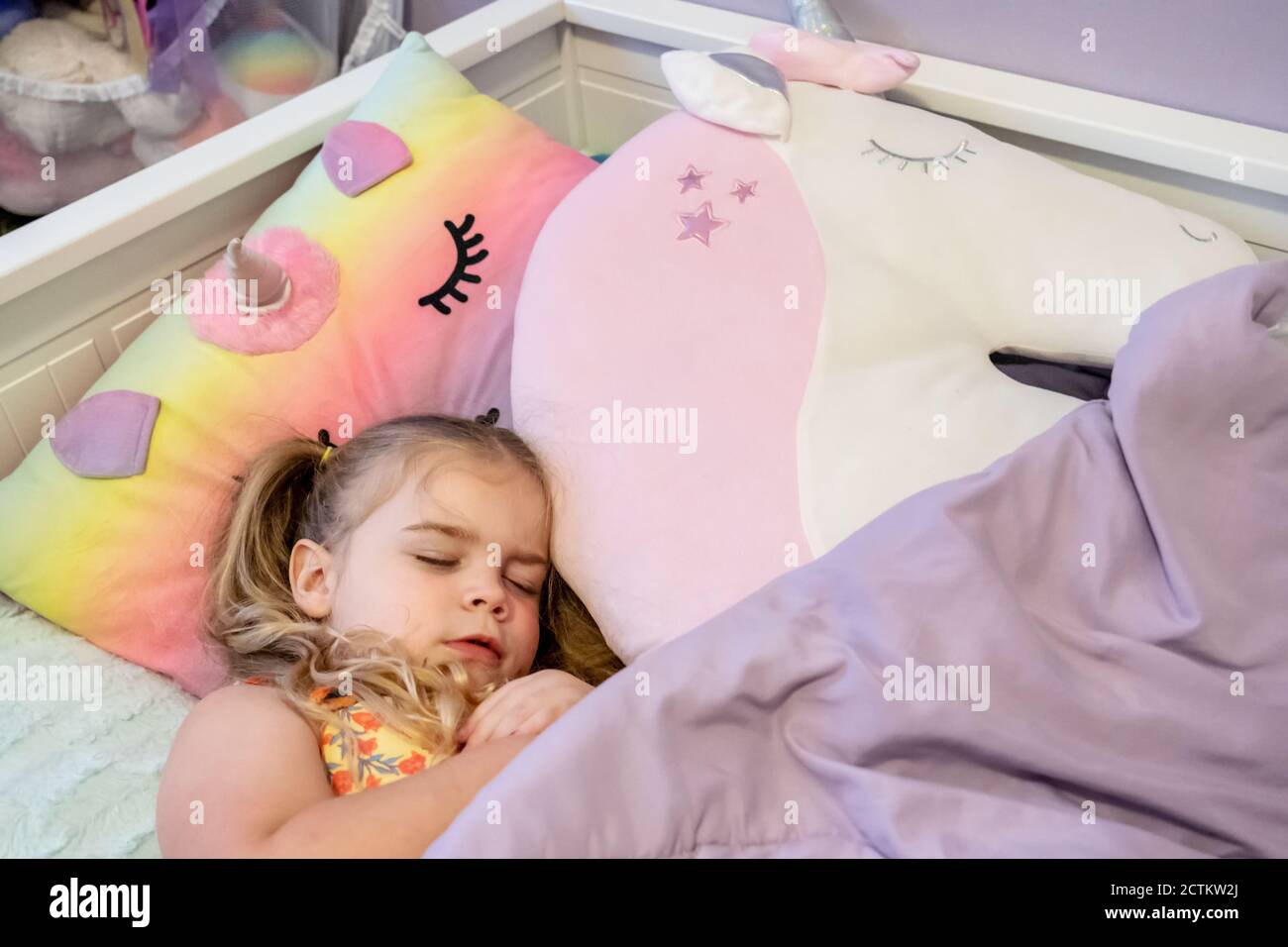 Giglio di 3 anni fingendo di addormentarsi in lei letto Foto Stock