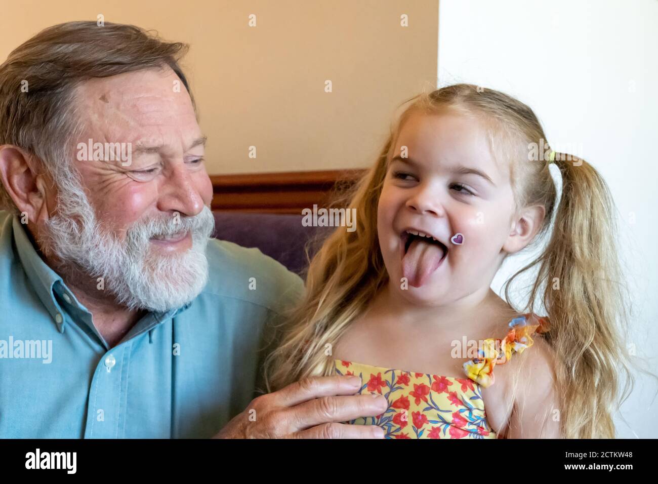 Lily, 3 anni, recita sciocco con il nonno Horton Foto Stock