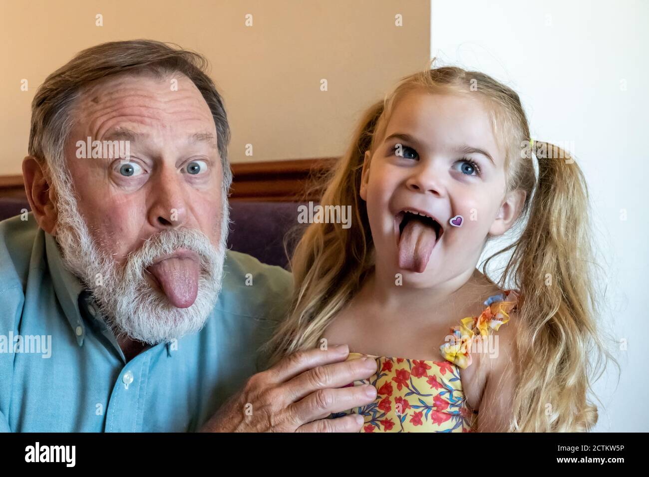 Lily, 3 anni, recita sciocco con il nonno Horton Foto Stock