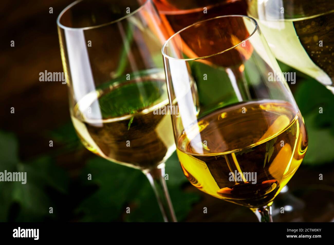Set di vini bianchi. Degustazione di vini, le varietà più popolari di vini bianchi in calici di vino su tavola di legno d'annata in stile rustico, focalizzazione selettiva Foto Stock