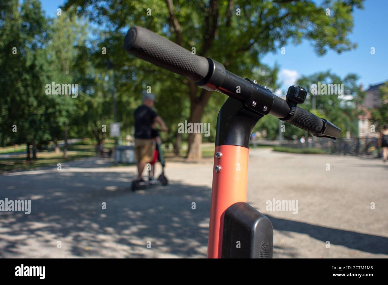 Tampere, Finlandia - 26 LUGLIO 2019. Un uomo che cavalca uno scooter elettrico con suo figlio nel parco pubblico in una soleggiata giornata estiva. Foto Stock