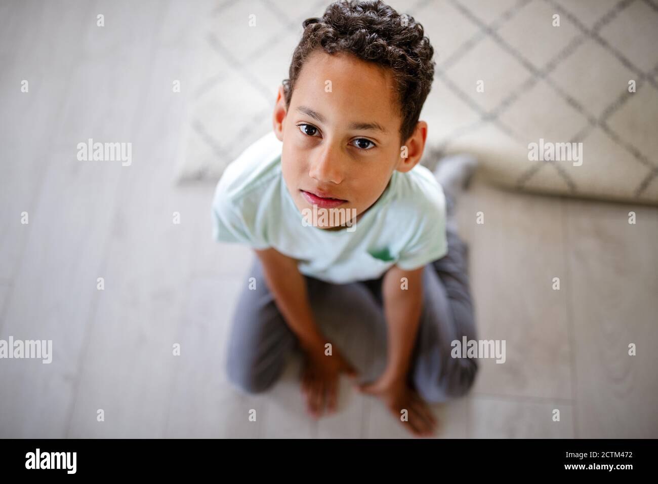 Ritratto del triste ragazzo africano seduto su un pavimento Foto Stock