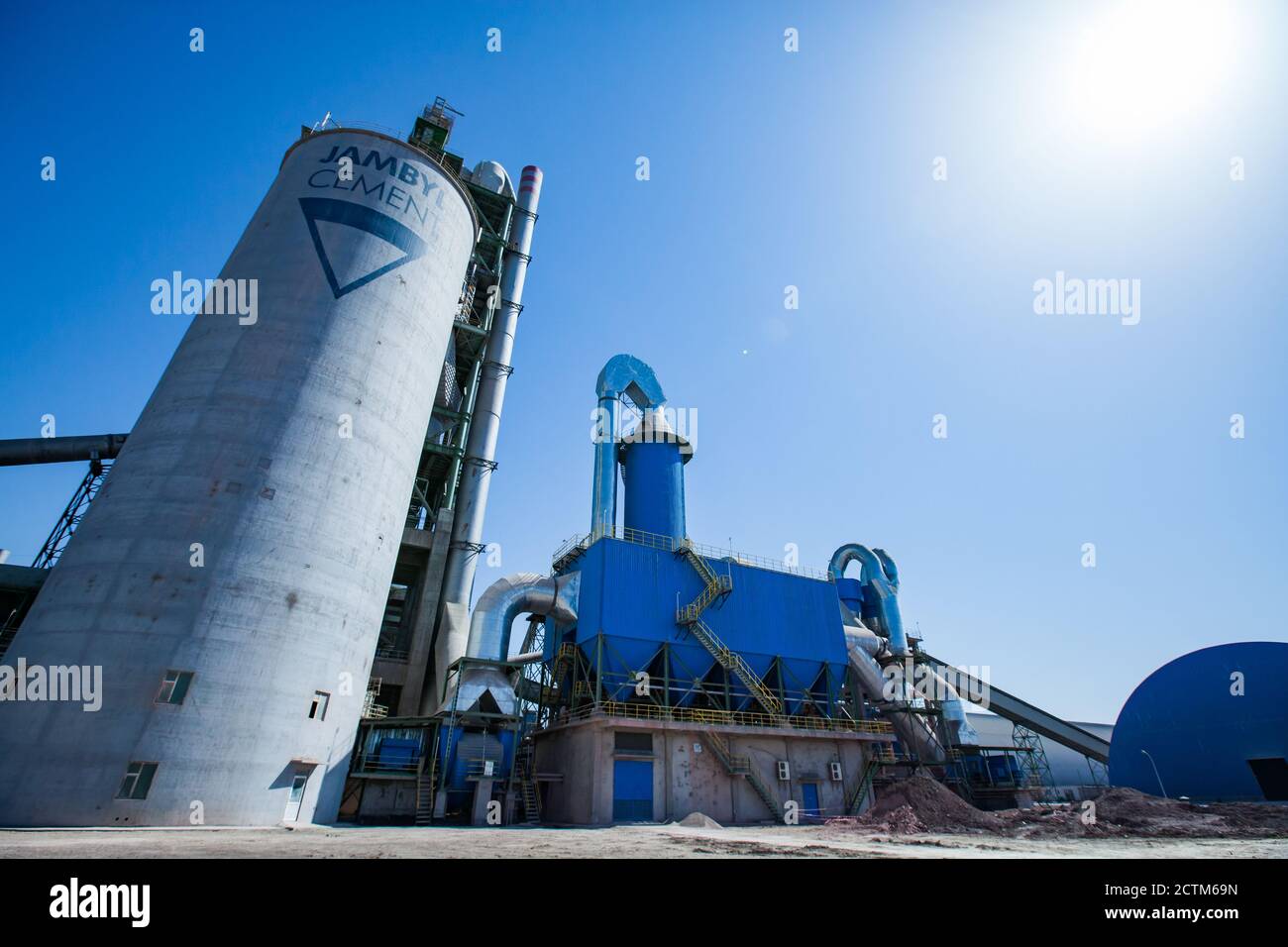 Mynaral/Kazakhstan - Aprile 23 2012: Moderno impianto di cemento Jambyl. Torre (silo) su cielo blu con sole. Vista panoramica dell'obiettivo grandangolare. Foto Stock