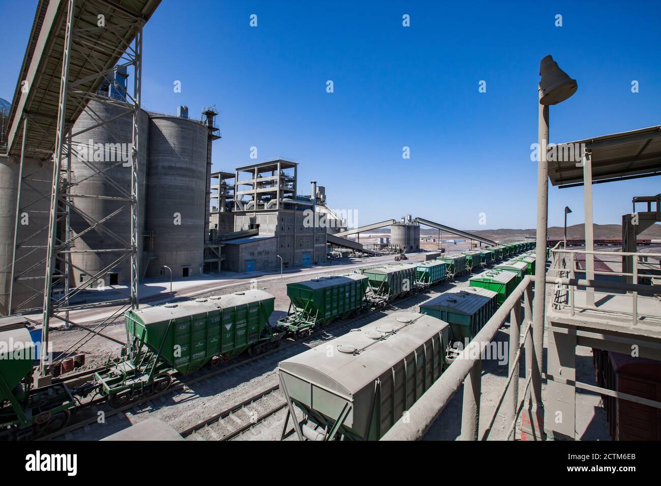 Mynaral/Kazakhstan - Aprile 23 2012: Stabilimento di cemento Jambyl. Terminal ferroviario del carico. Allenati su silo e sullo sfondo della costruzione della fabbrica. Foto Stock