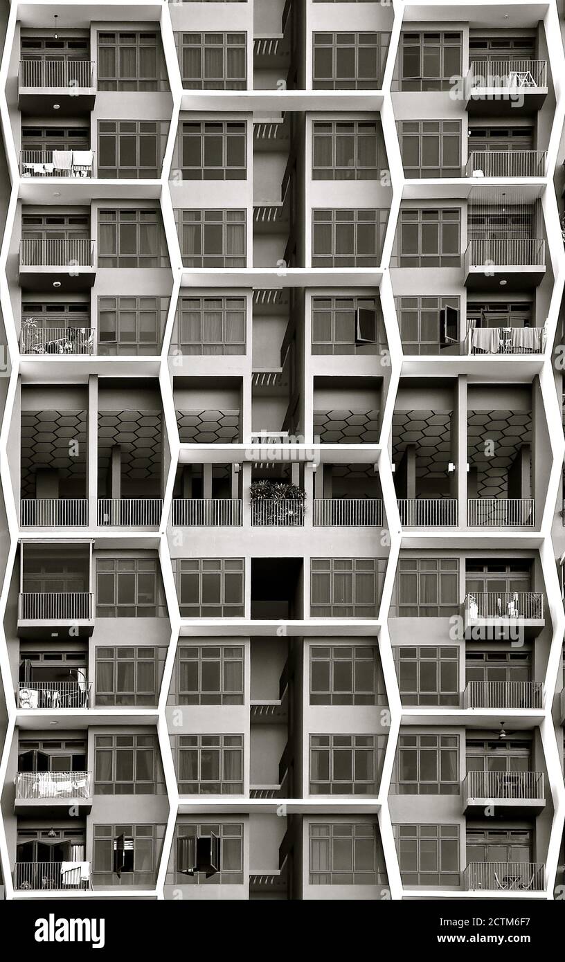 Un moderno complesso di appartamenti con design a nido d'ape esagonale sulla facciata di balconi e finestre. Foto Stock