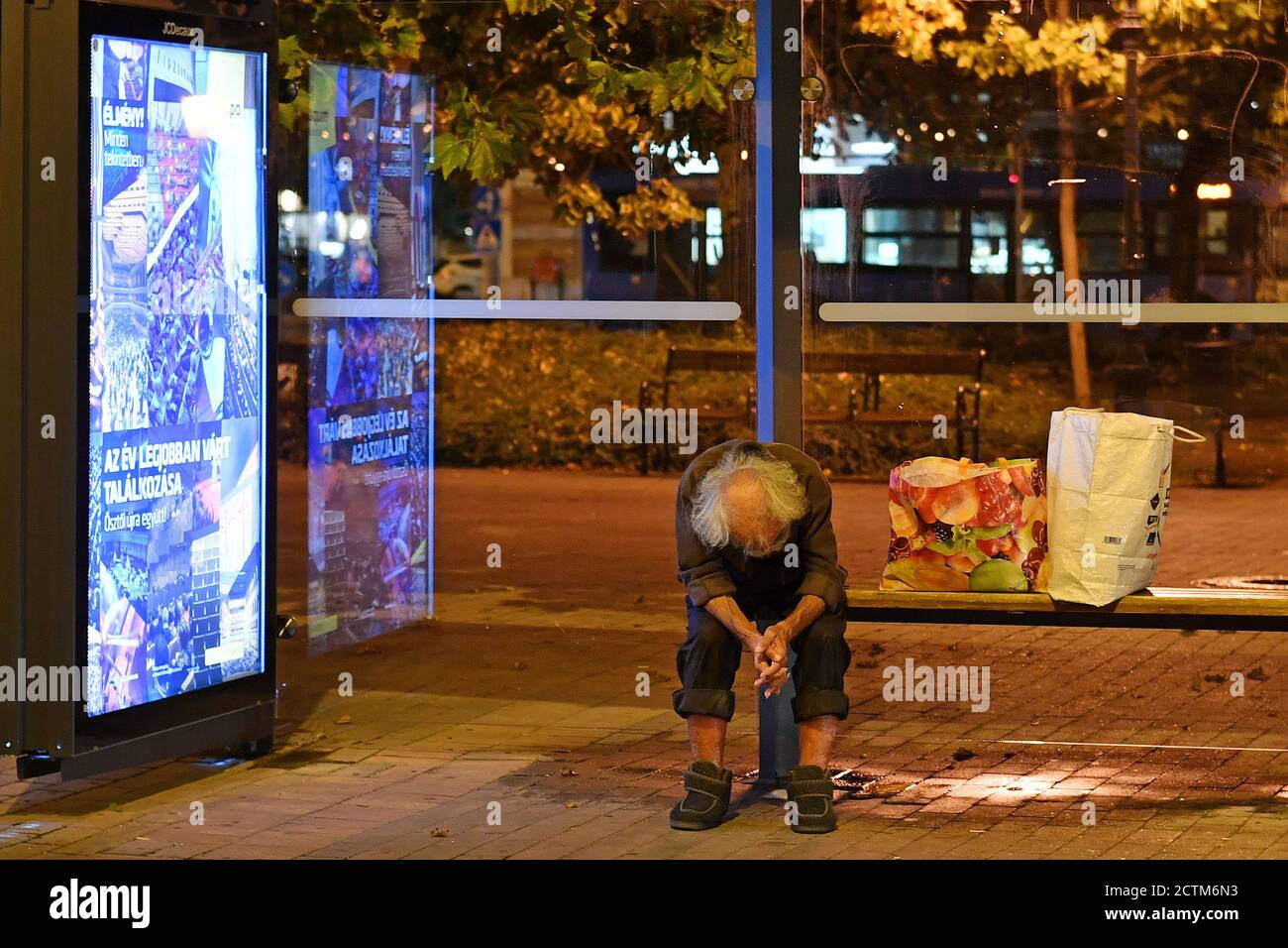 Budapest, Ungarn. 23 Settembre 2020. Un uomo senza casa si siede piegato in avanti ad una fermata dell'autobus, accanto a lui sono due borse di plastica. Aftertake, il 09/23/2020. | utilizzo in tutto il mondo credito: dpa/Alamy Live News Foto Stock