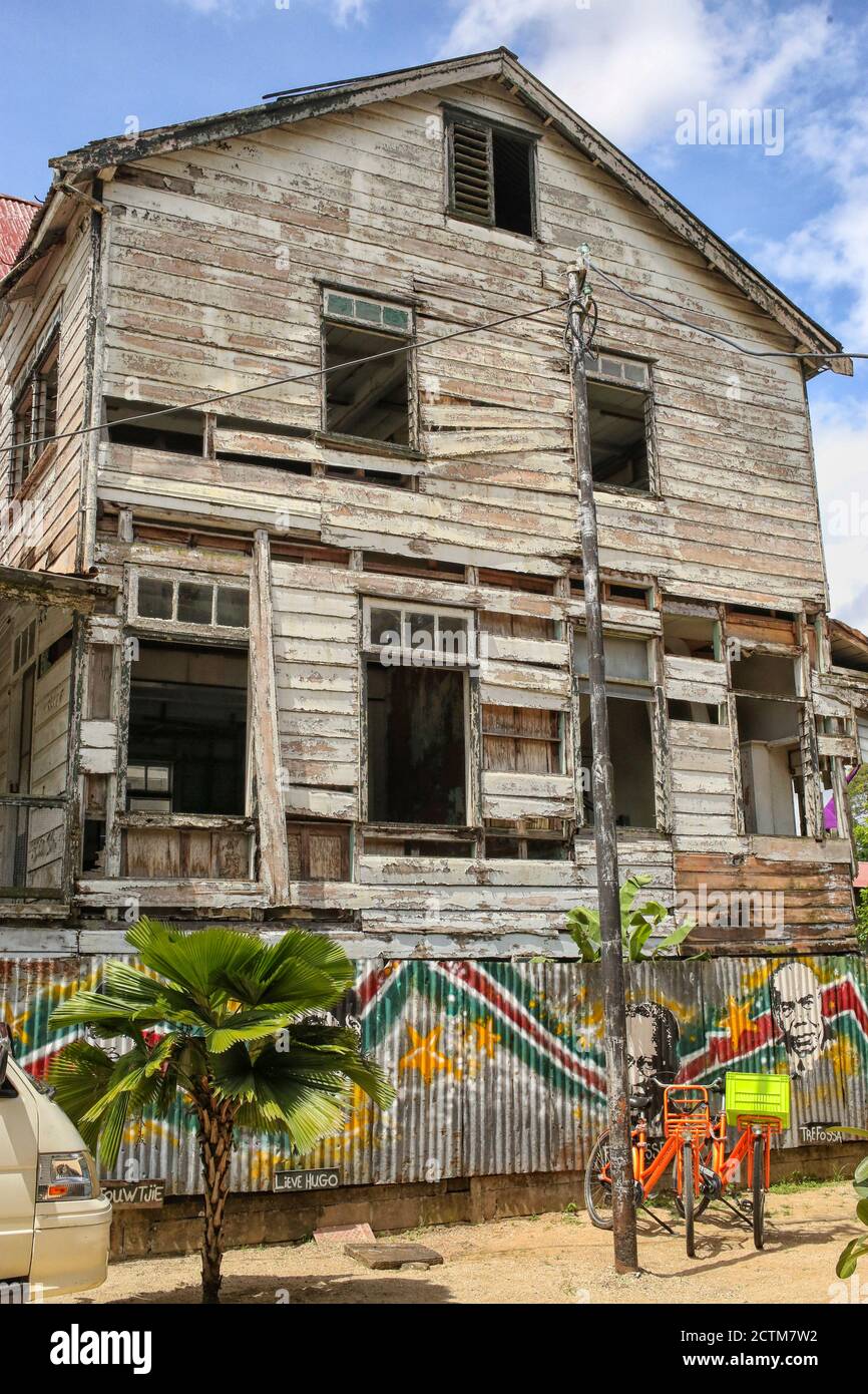 Due biciclette colorate di fronte alla casa di legno intemperie in Suriname, America Latina Foto Stock
