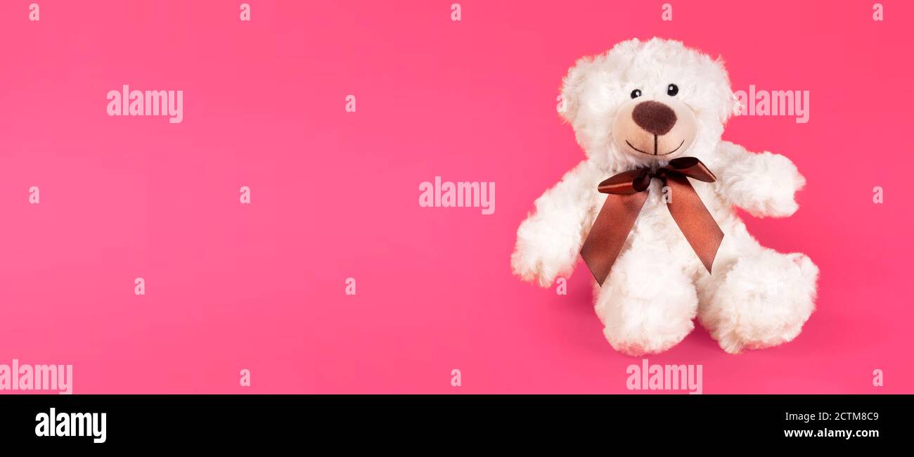 Teddy orso furry giocattolo per bambini isolato su sfondo rosa. Allegro e allegro orso romantico. Foto Stock