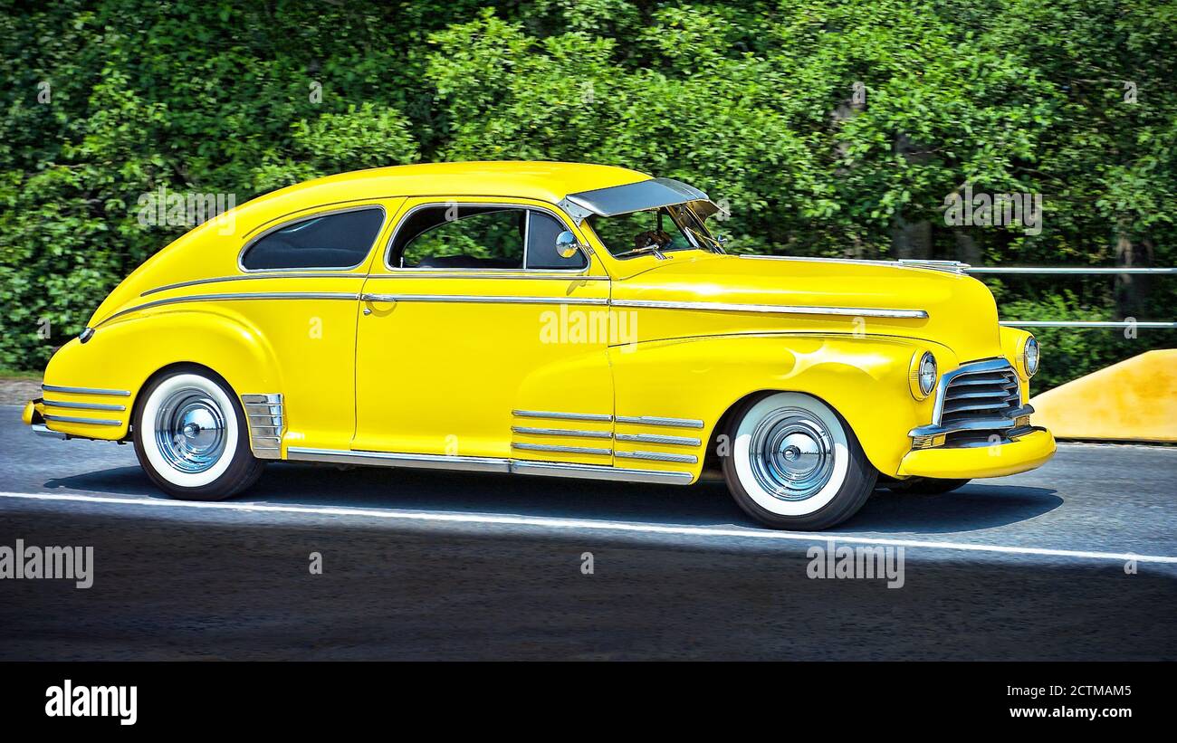 Primo piano di una bellissima berlina di colore giallo brillante degli anni '40, vista intorno a Vancouver, Canada, America del Nord. Nessuna persona presente. Foto Stock