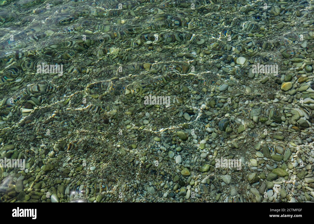 Pietre e Pebble nel mare azzurro limpido con il sole Riflessioni a Corfù  Grecia Foto stock - Alamy