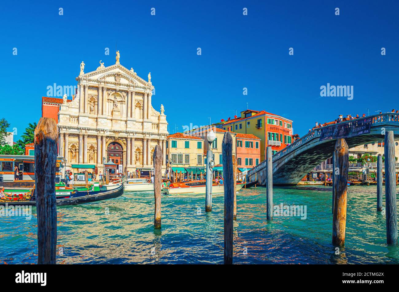 Venezia, 13 settembre 2019: Paesaggio urbano con yacht e gondole che navigano lungo il Canal Grande, Ponte degli Scalzi e Chiesa di Santa Maria di Nazareth, cielo blu nel giorno d'estate Foto Stock