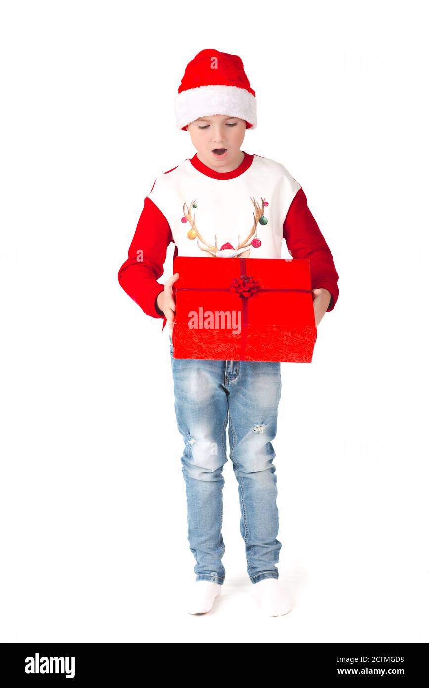 buon natale. Felice Anno Nuovo. Giovane scolaro caucasico in costume di Babbo Natale tiene un bambino rosso box.European nel cappello di Babbo Natale. Sfondo bianco Foto Stock