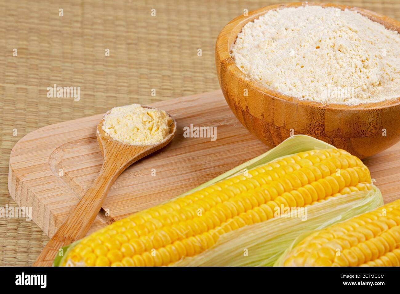 Ciotola di legno di farina di mais o di fiore di mais con corncobs su un sfondo di legno Foto Stock