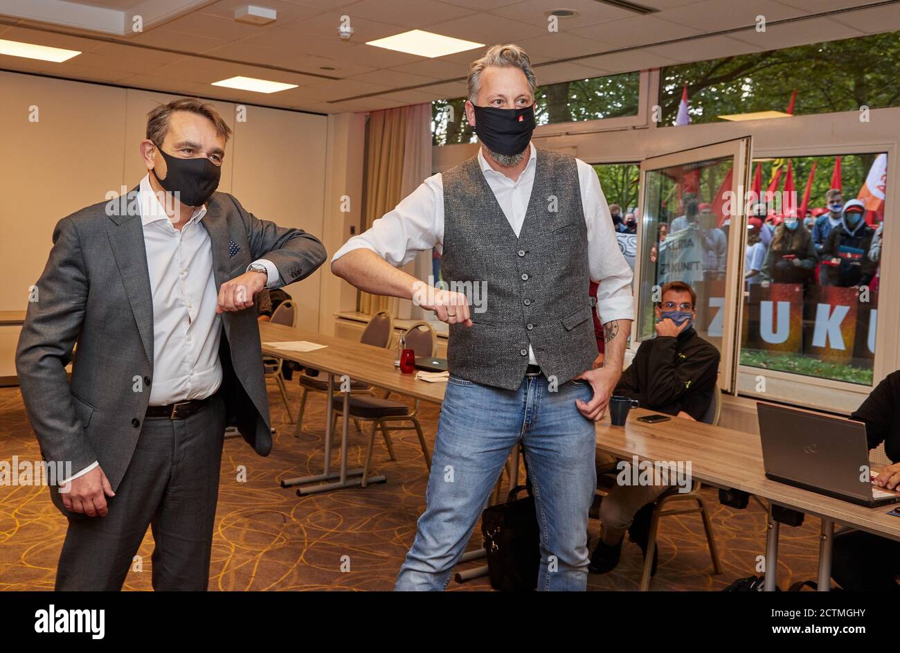 Amburgo, Germania. 24 Settembre 2020. Lars Immisch (l), responsabile delle risorse umane del Gruppo Airbus, e Carsten Bremer, negoziatore di IG Metall Küste, si danno il benvenuto in un hotel della Città Nord prima dell'inizio delle trattative collettive tra IG Metall e Airbus sulla sicurezza di luoghi e posti di lavoro. Sullo sfondo, i partecipanti ad un'azione di protesta possono essere visti davanti alla finestra dell'hotel. Credit: Georg Wendt/dpa/Alamy Live News Foto Stock