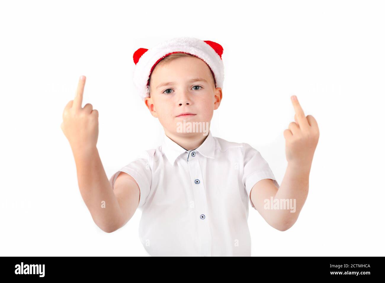 Ggesturing boy in cappello di santa che mostra il segno del dito medio,  sulla parete bianca dello studio Foto stock - Alamy