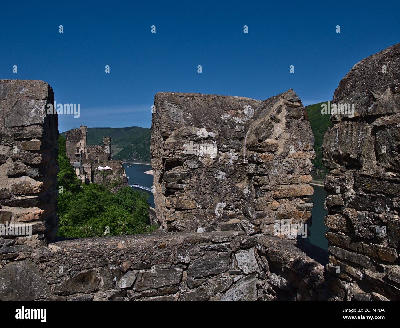 Vista del vecchio castello romanticismo Rheinstein tra due merli di un antico muro di pietra nella valle del fiume Reno vicino a Bingen, Renania-Palatinato. Foto Stock