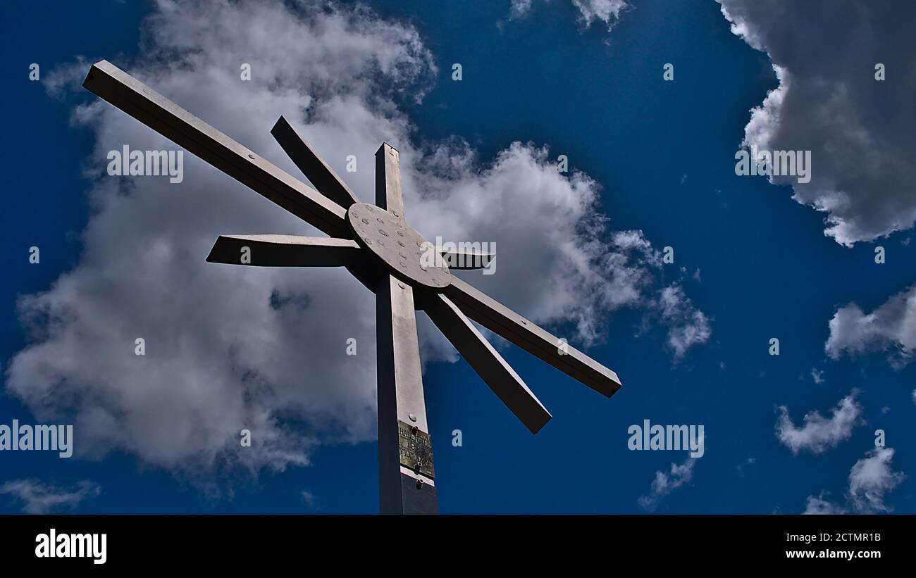 Croce sommitale, un simbolo religioso cristiano, sulla cima di una roccia di arenaria vicino a Dahn (Dahner Felsenland, Foresta di Palatinato). Segno: Nome del villaggio. Foto Stock