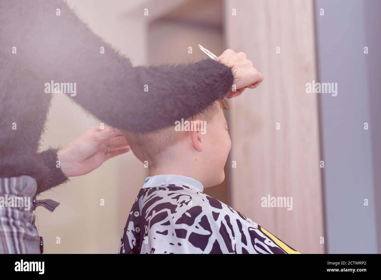 Ragazzo carino ottenere capelli dal parrucchiere al barbershop. Foto Stock