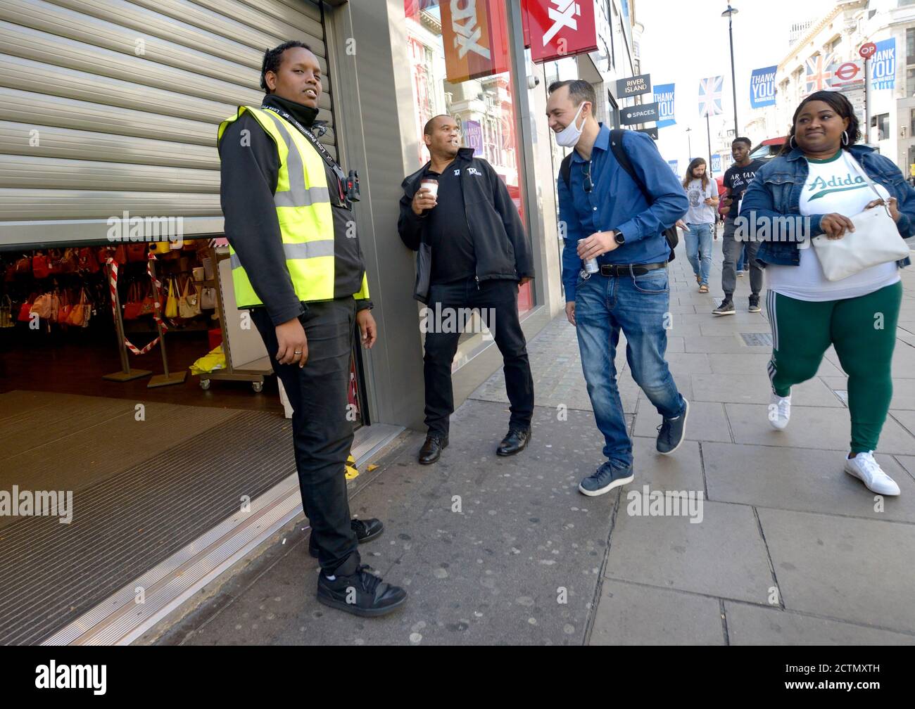 Londra, Inghilterra, Regno Unito. Guardia di sicurezza fuori da un negozio in Oxford Street. Uomo che indossa una maschera durante la pandemia COVID, settembre 2020 Foto Stock