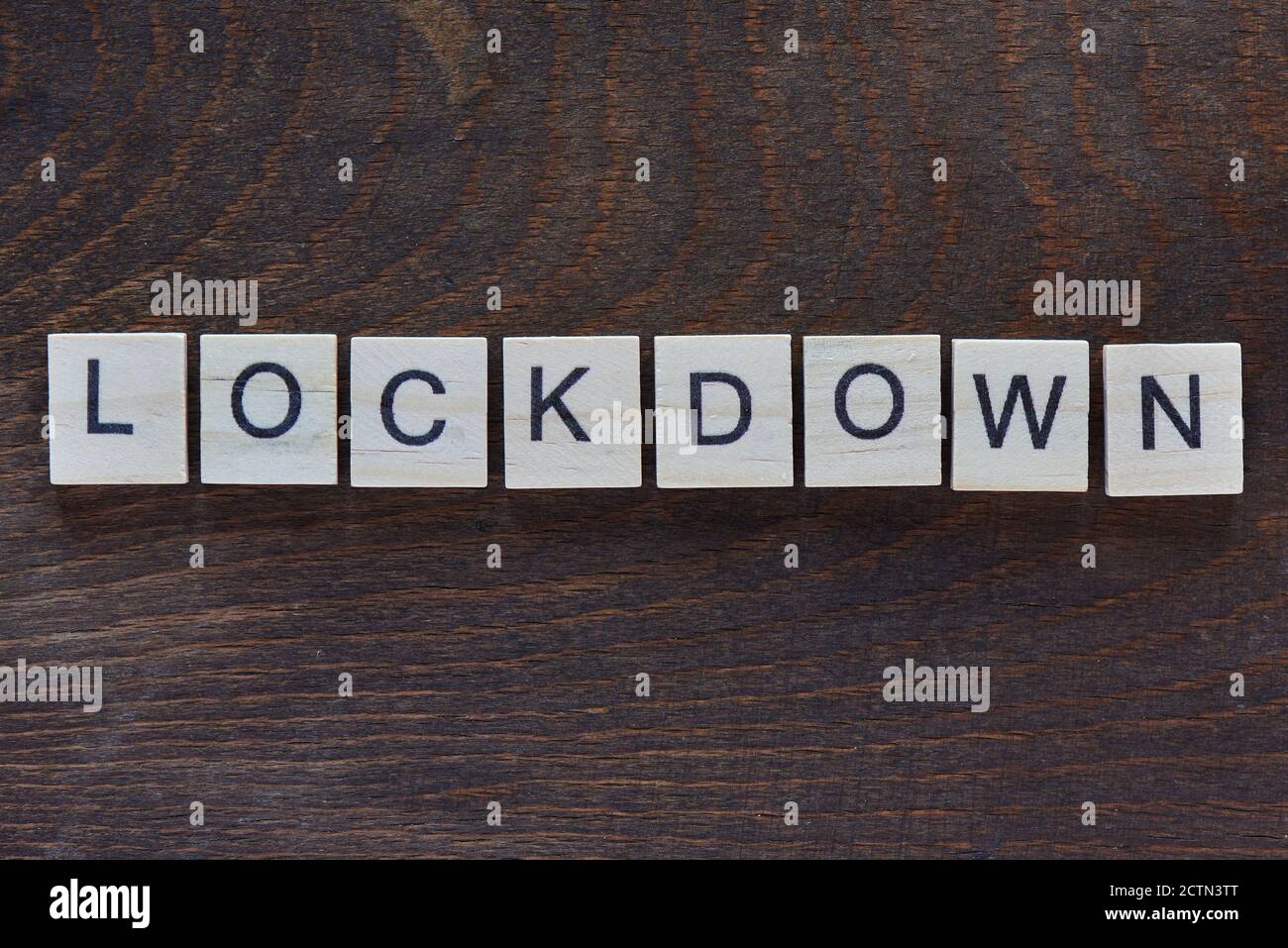 Scritto 'LOCKDOWN' con lettere di legno chiaro su legno scuro Foto Stock