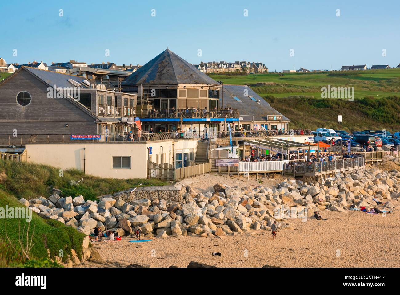 Fistral Beach bar, vista su una serata estiva di persone che si rilassano sulla terrazza fronte spiaggia del ristorante Fistral Stable, Fistral Beach, Newquay, Regno Unito Foto Stock