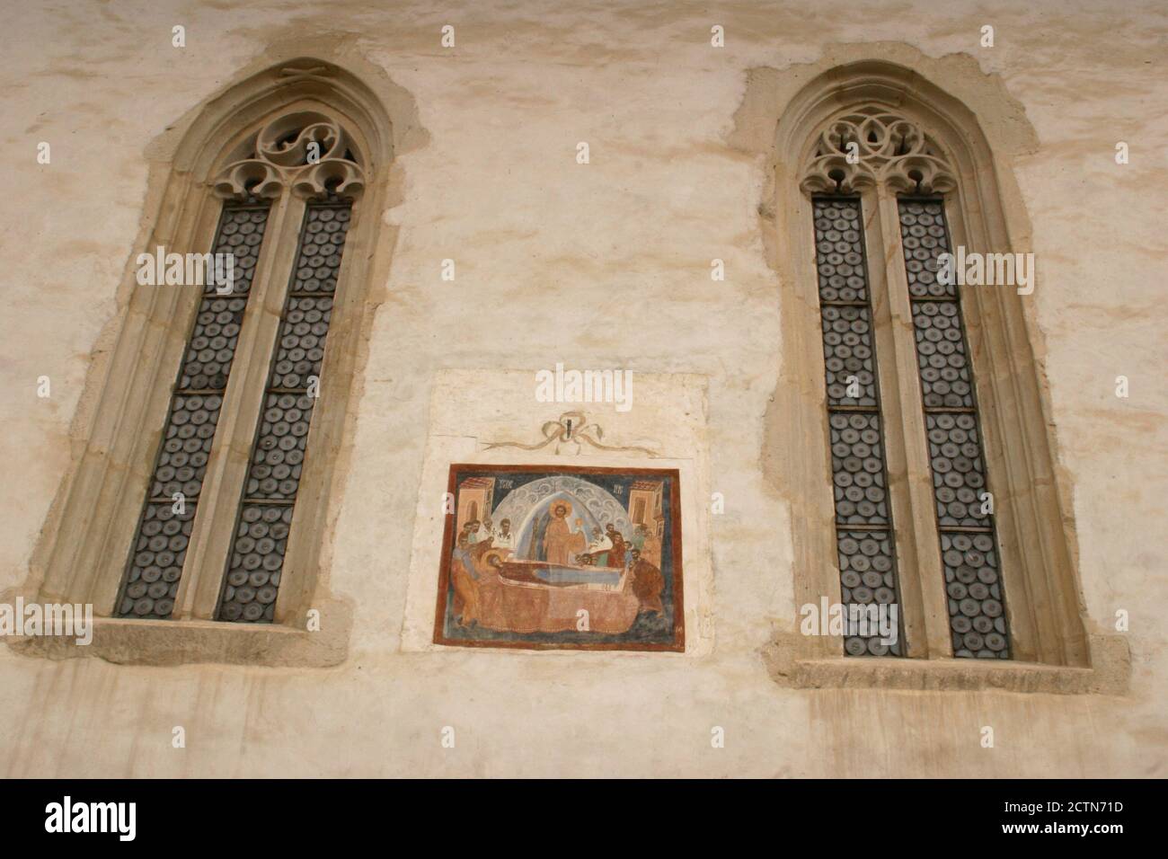 Vista esterna del Monastero della Bistrita cristiana Ortodossa, Romania. Grandi finestre gotiche e affresco raffigurante la Dormizione della Madre di Dio. Foto Stock