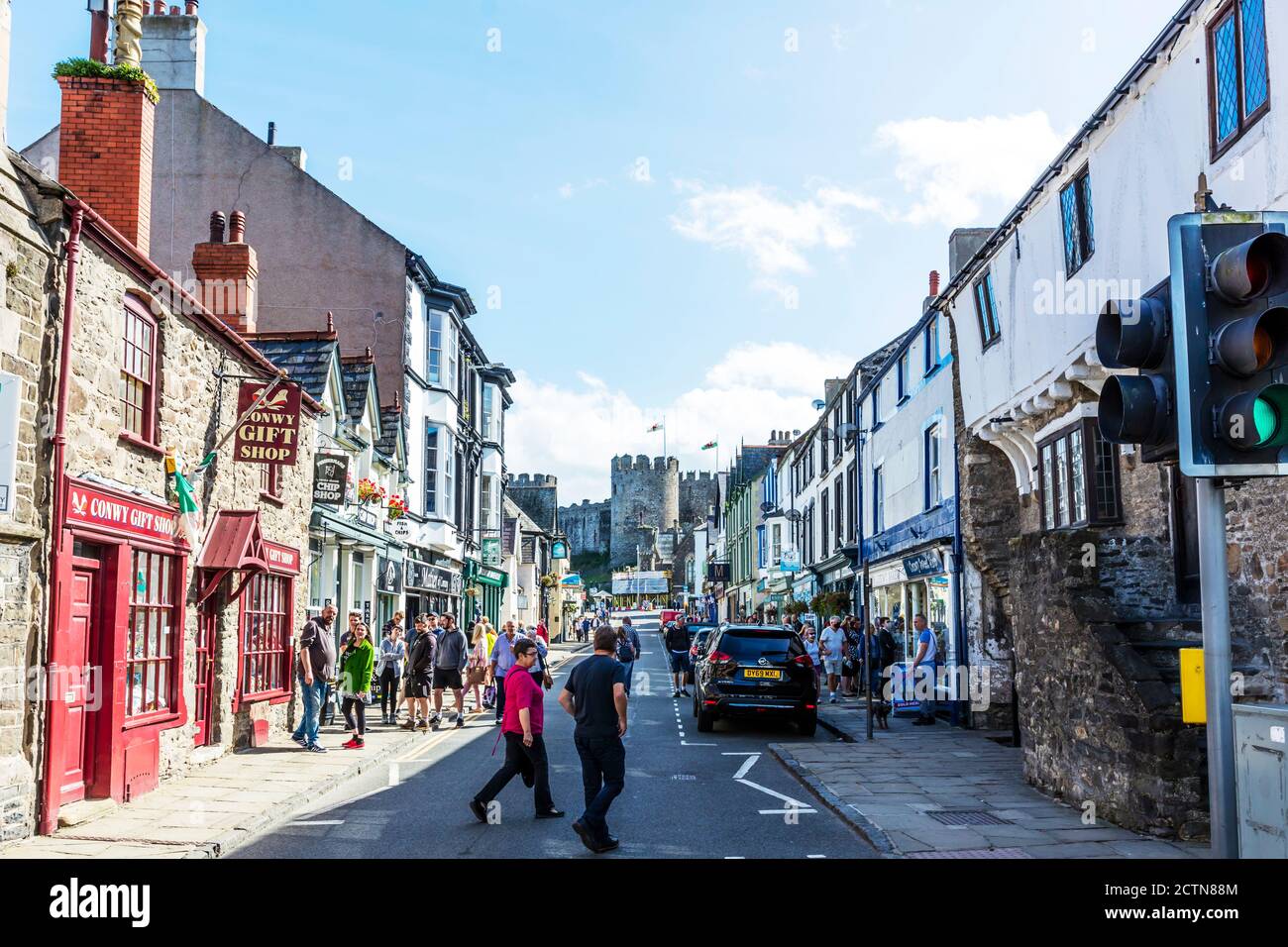 Conwy shopping con castello in background, Conwy, Conwy Town, Conwy Wales, Galles del Nord, Regno Unito, negozi, castello, strada, strada, Conwy Castle Foto Stock