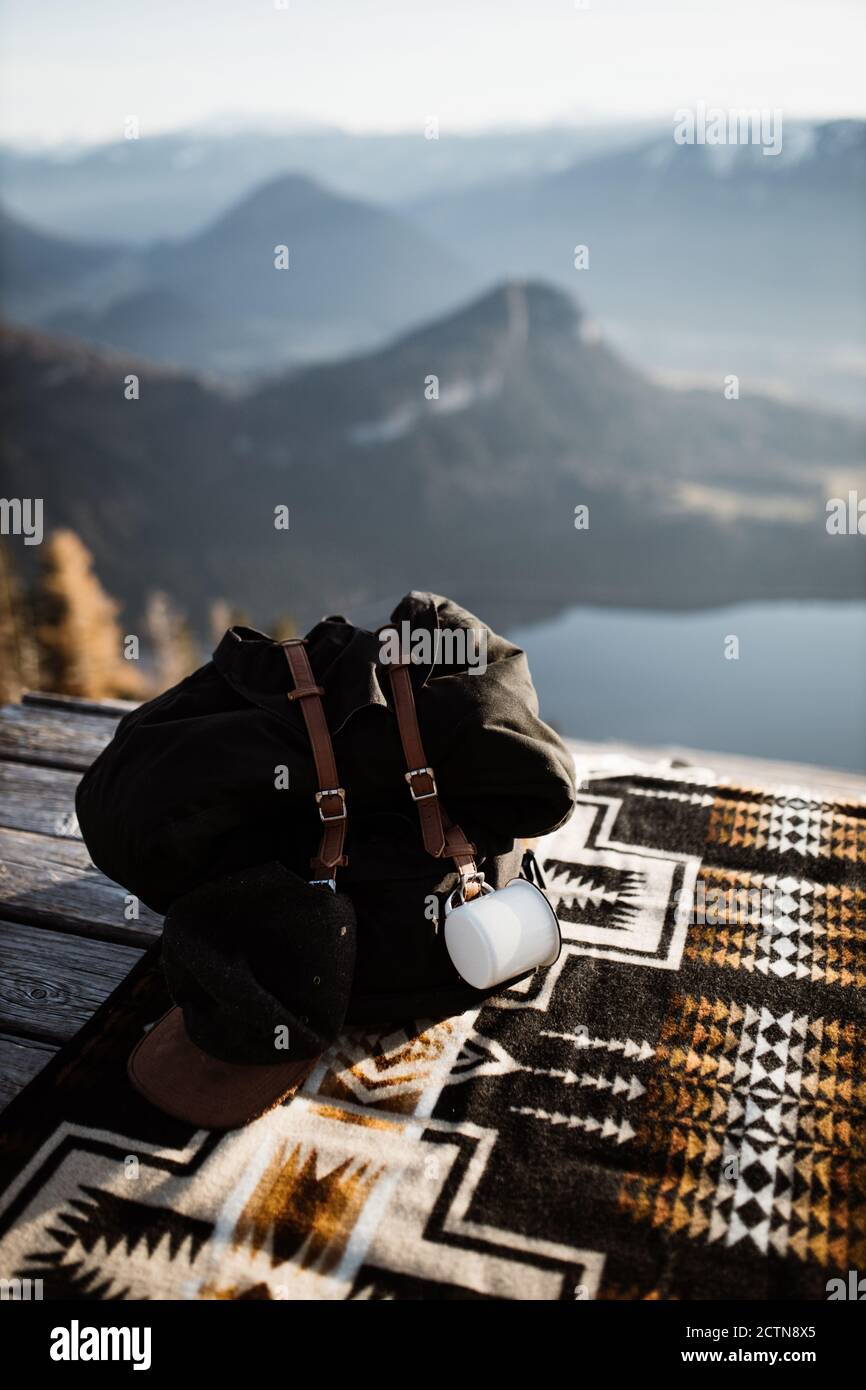 Zaino e fotocamere retrò posizionati su coperta di legno terrazza sullo sfondo di paesaggio montuoso Foto Stock