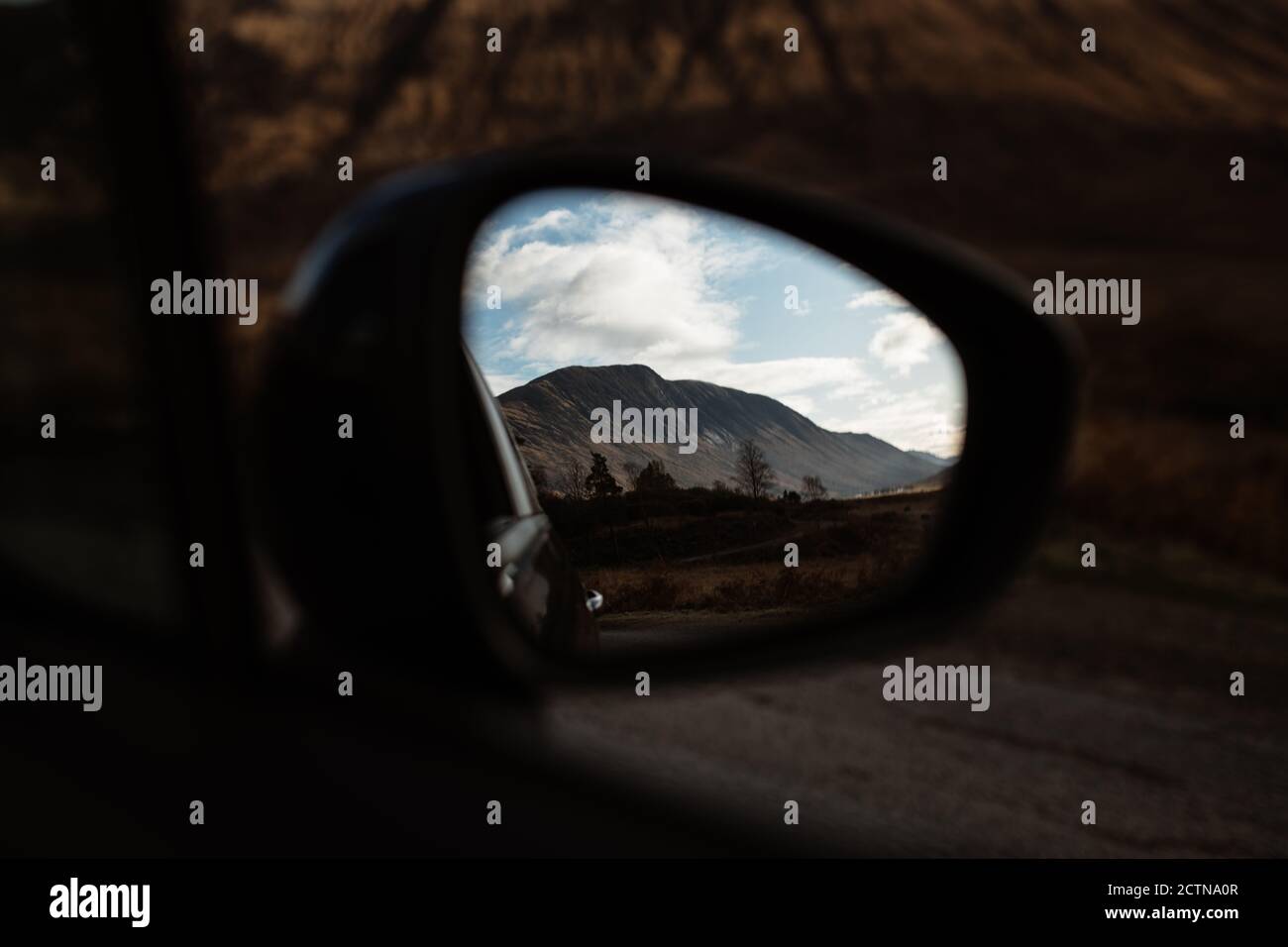 Incredibile vista della cima rocciosa della montagna in autunno dalla finestra Di auto nelle Highlands scozzesi Foto Stock