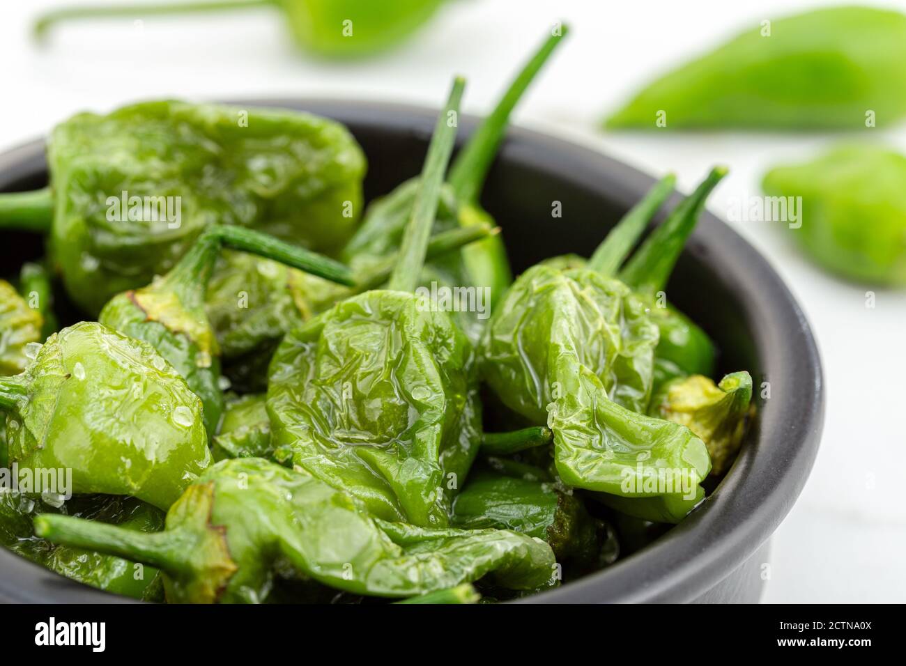 Peperoni cotti con olio d'oliva e sale marino. Tapas spagnole tradizionali Foto Stock