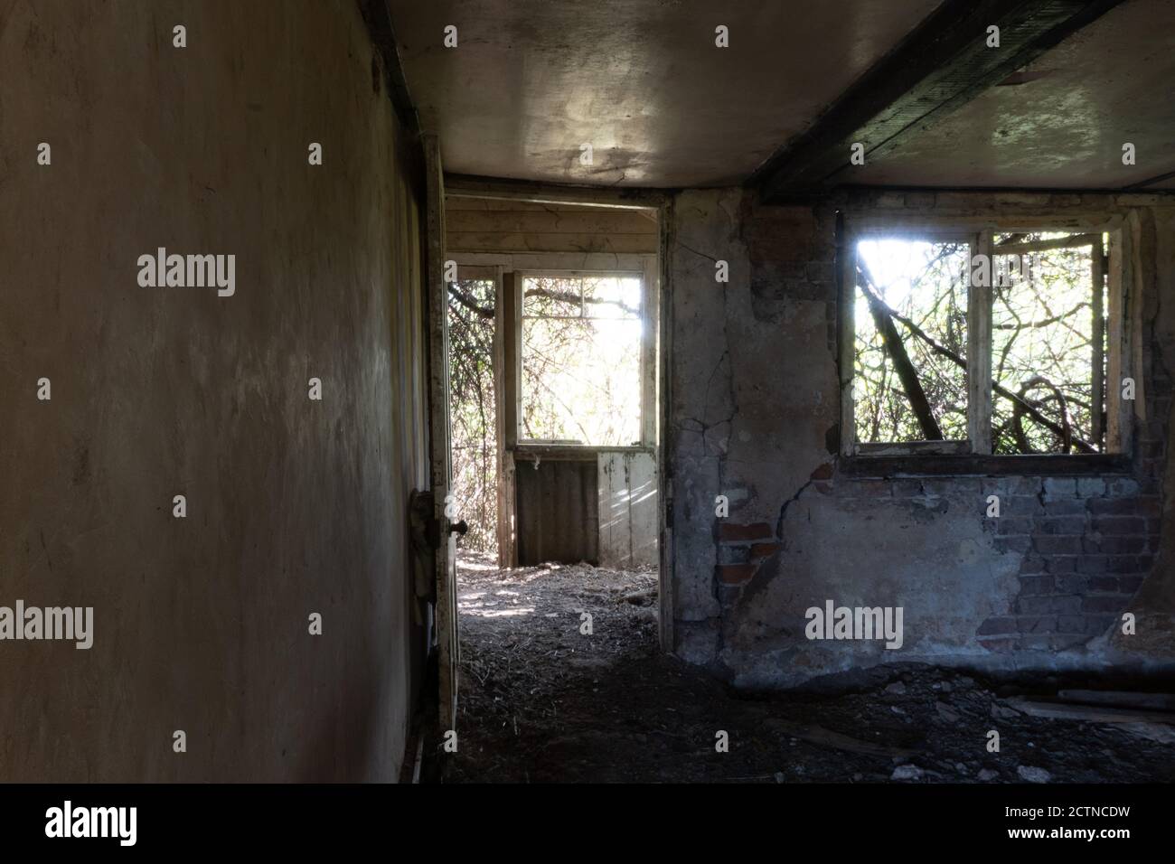 Guardando attraverso la porta di una decadente vecchia casa in rovina in campagna. Foto Stock