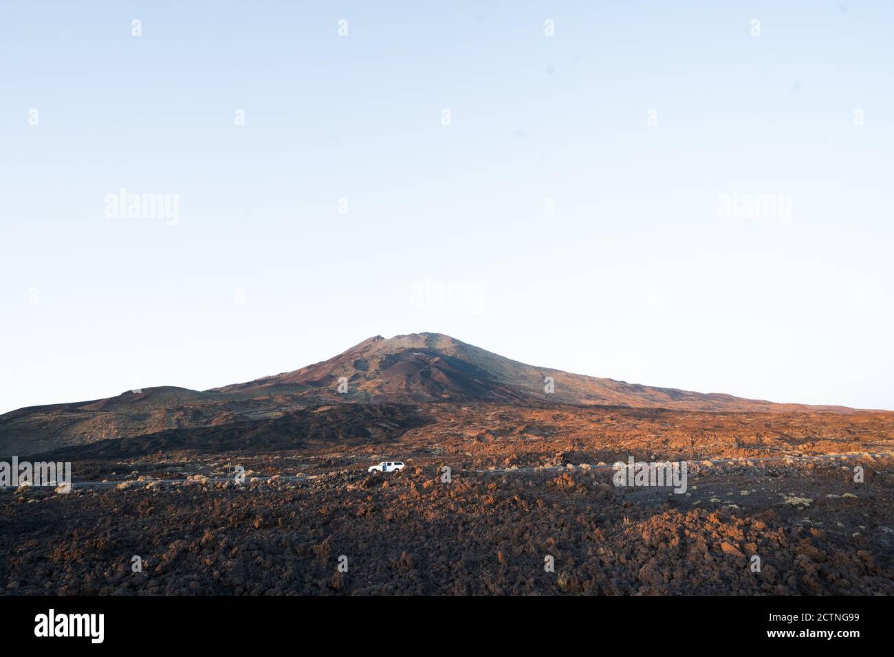 Guida in auto attraverso il magnifico paesaggio di secca valle rocciosa e. Catena montuosa sotto il cielo blu e senza nuvole al tramonto a Tenerife Foto Stock