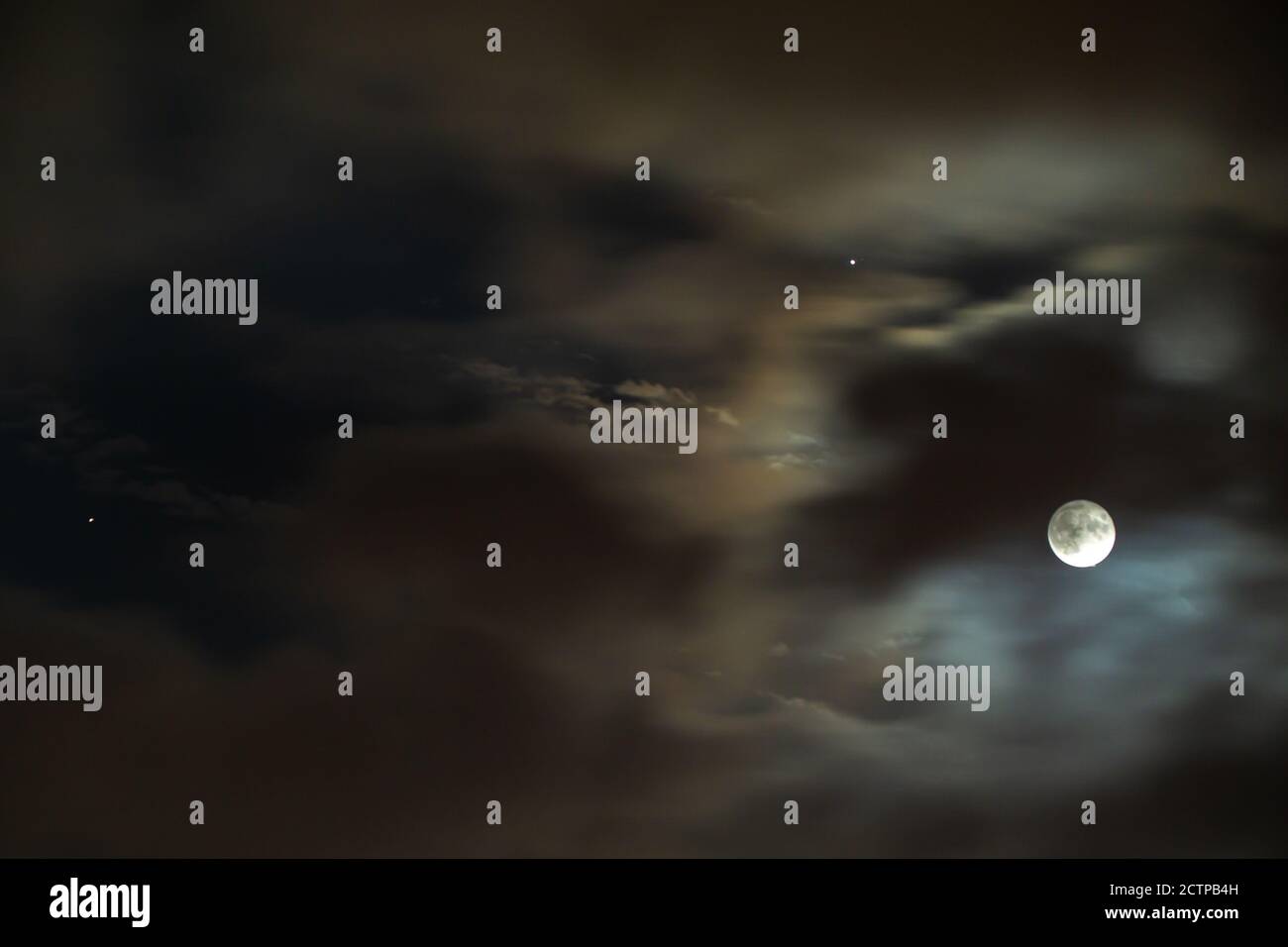 Luna piena, Giove e Saturno nel cielo nuvoloso notturno Foto Stock
