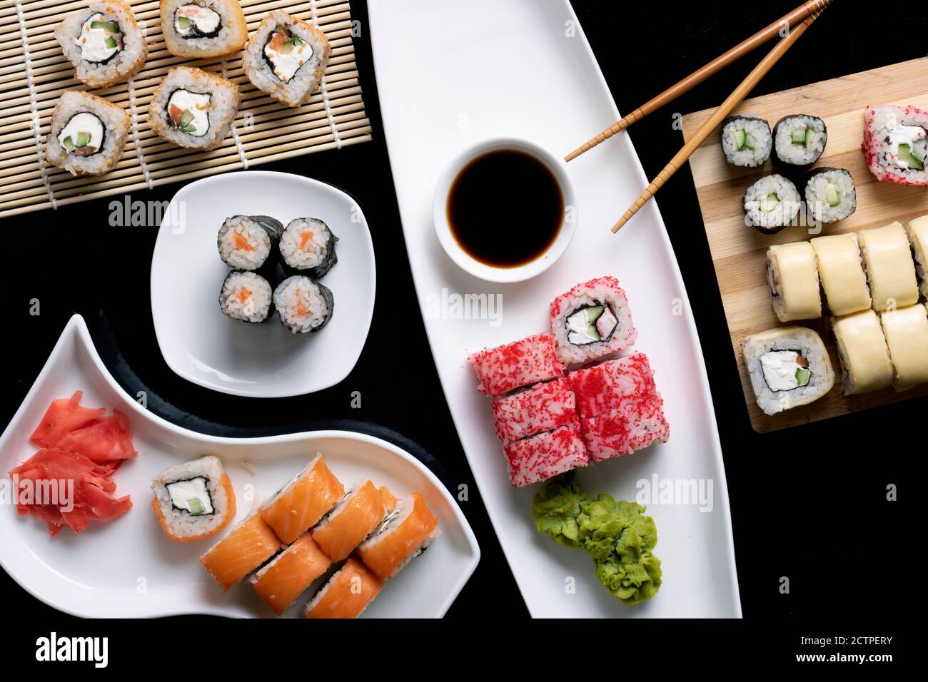 Set di sushi con salsa, chopsticks su tavolo nero Foto Stock