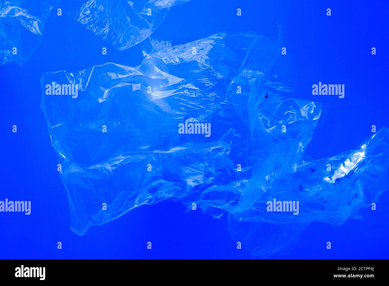 Sacchetti di plastica trasparenti che galleggiano sott'acqua nell'oceano blu, inquinamento da rifiuti di plastica non biodegradabili, pericolo per la fauna marina Foto Stock