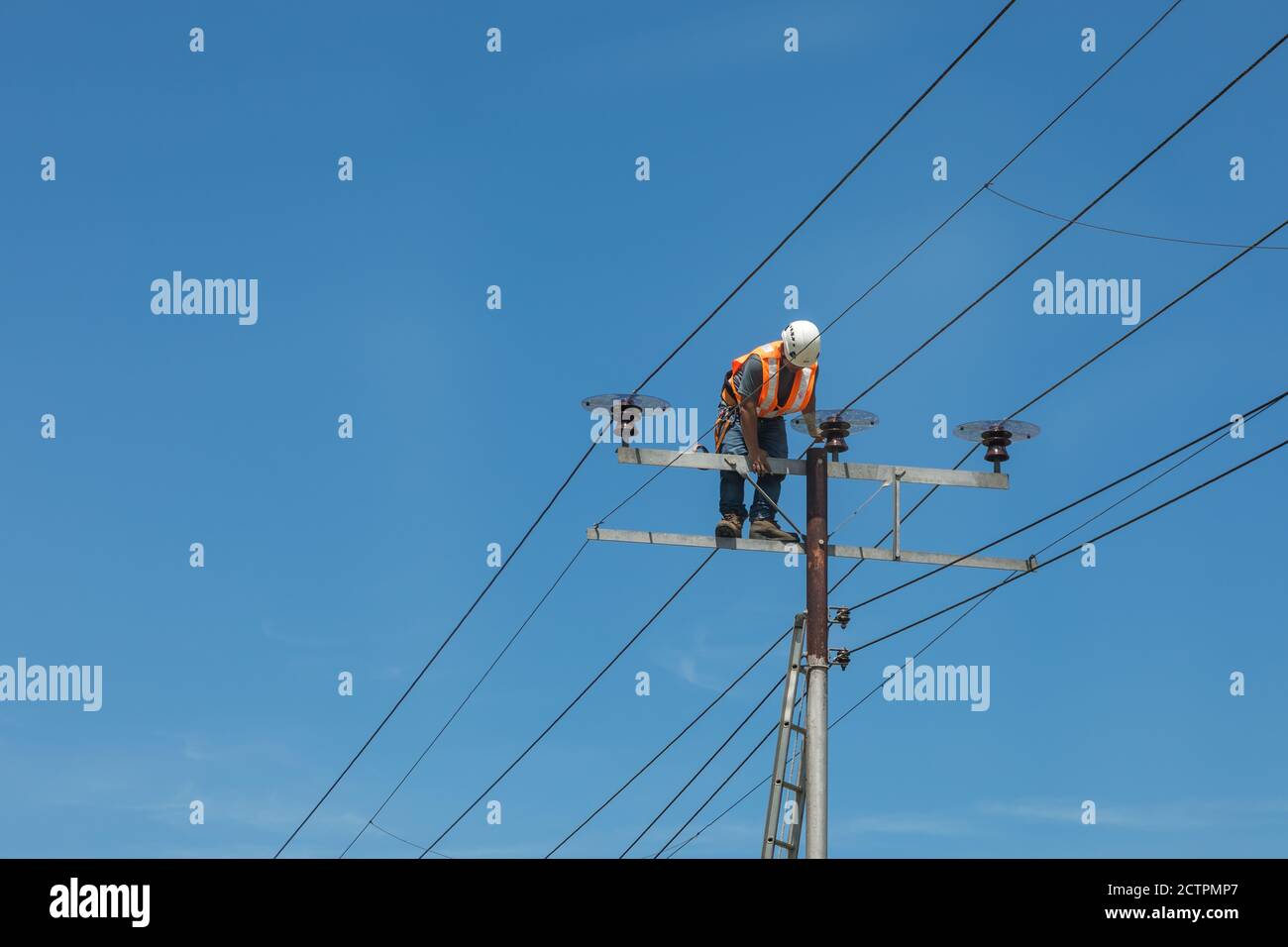Tenhilan, Sabah, Malesia: Un uomo di linea non protetto sta salendo sulla cima di un pilone ad alta tensione a Tengilan, incline a una caduta pericolosa. Foto Stock