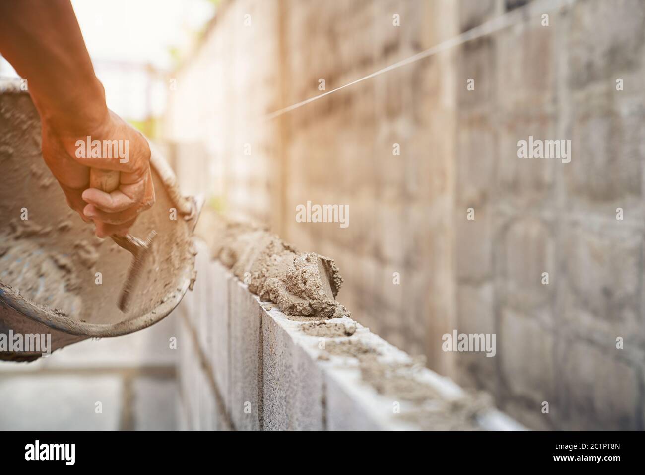 Operaio costruendo mattoni di muro con cemento locale Thailandia Foto Stock