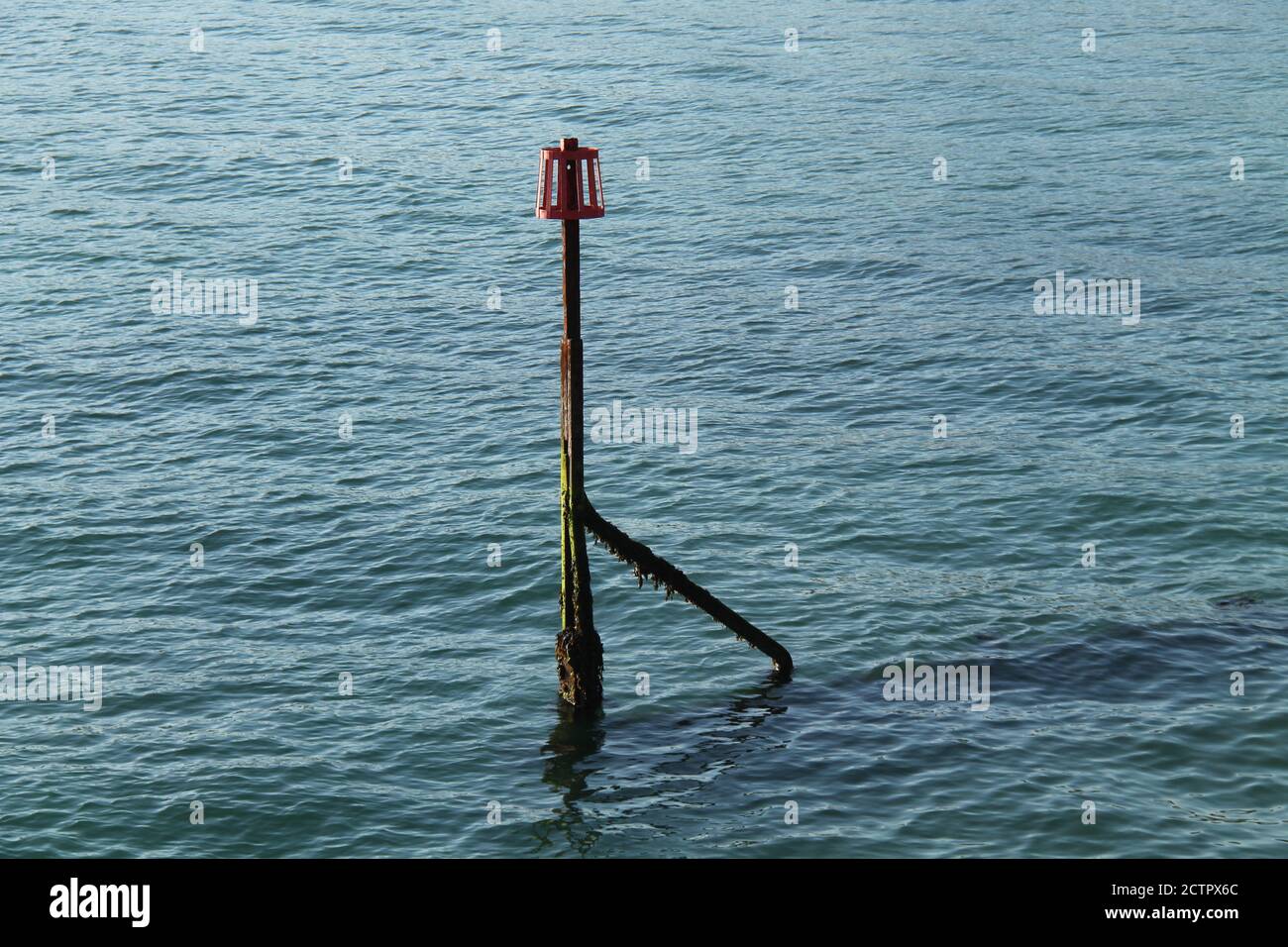 Il marcatore alla fine di un Groyne di legno a lato del mare. Foto Stock