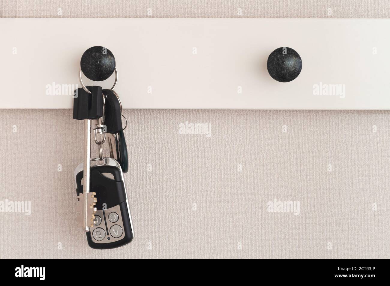 Un mazzo di chiavi pende su un gancio di vestiti dentro il corridoio Foto Stock
