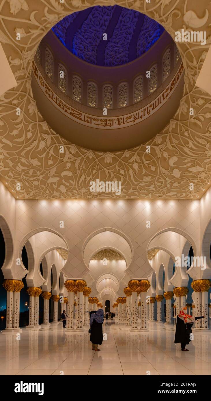 Donne arabe che prendono immagini selfie del cellulare nel corridoio a cupola della Grande Moschea Sheikh Zayed ad Abu Dhabi, Emirati Arabi Uniti Foto Stock
