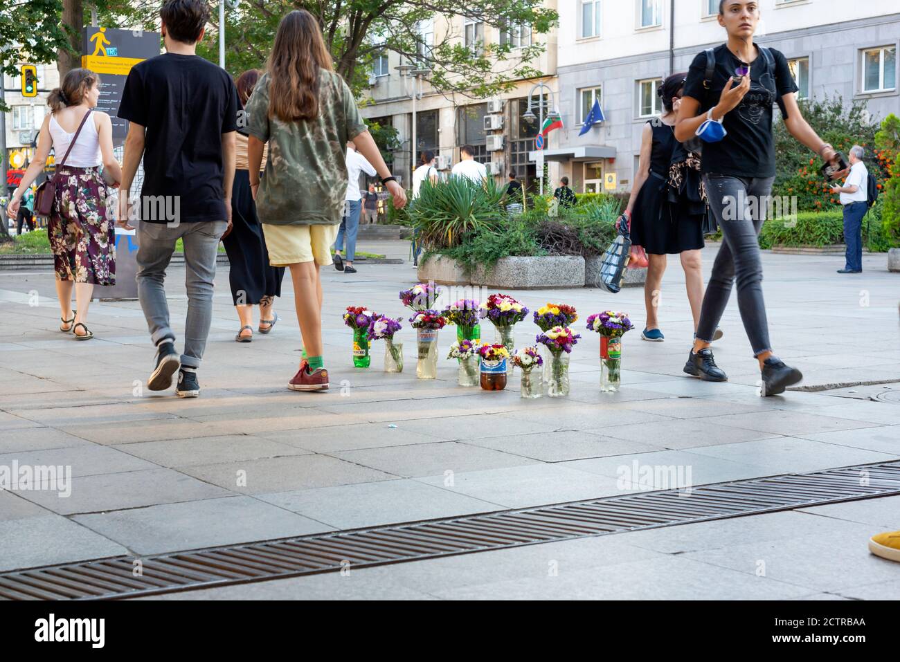 Fiori in vendita esposti in bottiglie di plastica improvvisate come vasi sul marciapiede nel centro di Sofia, Bulgaria, Europa orientale, Balcani, UE Foto Stock